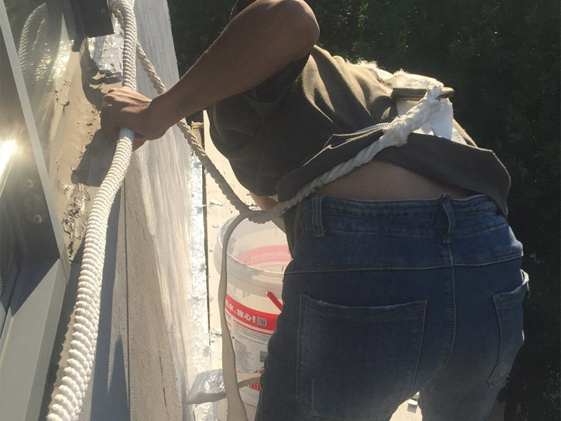 高空外墻粉刷裝修:1、基層處理：在對外墻粉刷之前，首先需要將墻面基層的灰塵與雜志清理干凈，那些比較破舊的層面與耐水性較差的涂層需要鏟除，如果表面有凹凸不平的地方，則需要用水泥砂漿進行抹平。2、刷底膠：在對墻面刷底膠時，需要先將膠水按照說明書上注明的比例進行稀釋，稀釋好之后，再將膠水用輥筒均勻涂刷墻面兩遍左右，注意膠水的薄厚要均勻，不能過多也不能過少。3、局部補膩子：基層底膠干燥之后，則需用膩子將墻面找平。4、滿刮膩子：膩子放在托板之上，讓后再用橡皮刮板對墻面進行涂刷，最好從上往下涂，最好涂刷2到三遍，需要注意的是，膩子不能涂刷太厚，膩子涂刷后需要用砂紙進行打磨，打磨力度需要合適，打磨完之后需要將表面灰塵給清除。5、刷底涂料：采用滾筒對墻面涂刷，涂刷時需要均勻，不能漏刷，也不能刷得過厚，底料干后，如果表面有要進行修補的地方，最好用膩子進行修復(fù)在進行砂平。