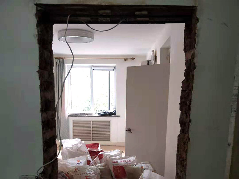 墻面開門洞：把砸去400mm高，寬2340mm的墻，全部用鋼筋混凝土澆筑。內(nèi)配上下各3根直徑12mm的帶肋鋼筋，箍筋直徑6mm，間距200mm，扎好鋼筋放上。支模，注意一側(cè)模板要支成◢形，高度為450，混凝土從該斜口倒入澆筑與斜口平，已高出了圈梁底50mm，即能使其與圈梁底充分咬合。拆模把多余部分鑿除。 應(yīng)在過梁部位先開洞做好過梁，再開門洞，每邊大于100mm，植2根10個鋼筋交門邊柱作為門垛。鋼筋混凝土過梁在普通磚墻上擱置長度應(yīng)不小于24cm,也就是一磚的厚度，而實(shí)際上門口是38墻，所以過梁一般是38cm； 門洞墻體高建議敲頂部梁面鑿洞再皮皮敲兩邊敲凹凸?fàn)畈孔隽涸倨鲋鎵w直接底洞容易整版墻敲壞松玩且能塌肯定玩洞直接鉆洞。