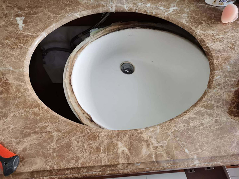 洗臉盆脫落維修:陶瓷臉盆下邊必須用架子托住，與石材臺板用普通玻璃膠密封，這樣臺板和臉盆就允許發(fā)生一定的相對位移，封膠的目的是不漏水，絕對不能用結構膠把臉盆與臺板粘死靠膠來承受陶瓷臉盆的重量；應該靠下面的托架托住陶瓷臉盆；否則一旦盆中放滿熱水，盆體受熱膨脹，而盆邊與臺板粘死不能變形，巨大的內(nèi)應力就會損壞陶瓷臉盆，嚴重時就會掉底。