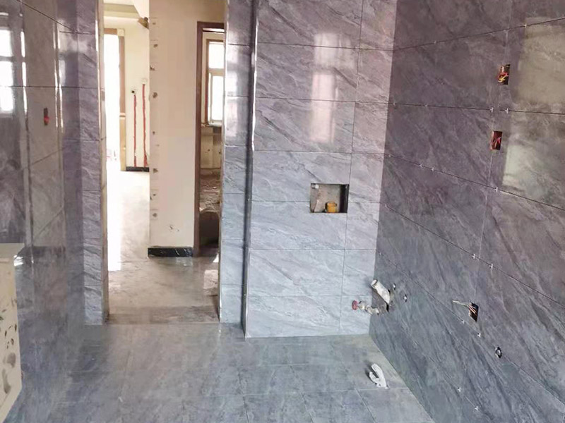 全屋瓷磚鋪貼：首先應(yīng)除去基層表面的污垢，油漬，浮灰;除去基層上所有涂料層，膩?zhàn)訉?如果基層未能達(dá)到平整度要求，需對(duì)基層進(jìn)行預(yù)先的找平處理。鋪貼瓷磚前需事先找好垂直線，以此為基準(zhǔn)鋪貼的瓷磚高低均勻、垂直美觀;此外，施工前在墻體四周需彈出標(biāo)高控制線，在地面彈出十字線，以控制地磚分隔尺寸。加水后將粘結(jié)劑漿料攪拌至潤滑均勻，無明顯塊狀或糊狀結(jié)塊，攪拌后的漿料靜置5-10分鐘后再稍加攪拌1-2分鐘即可使用。將瓷磚平整地鋪貼在基層上，使用橡膠錘將瓷磚拍實(shí)鋪平。施工過程中，可小幅度轉(zhuǎn)動(dòng)瓷磚，使?jié){料與瓷磚背面充分接觸。